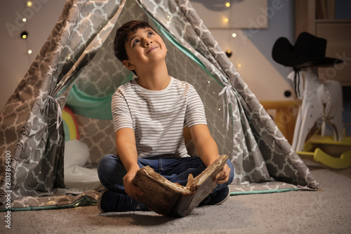 Dreaming cute boy reading a...