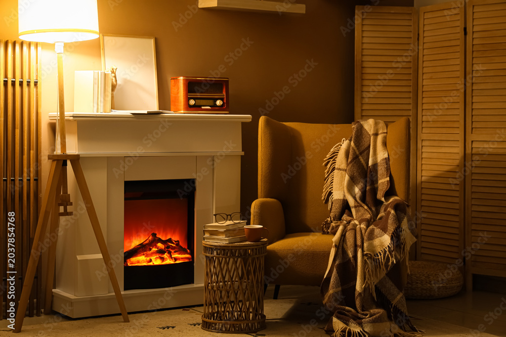 Fototapeta premium Interior of living room with books, fireplace and armchair at night