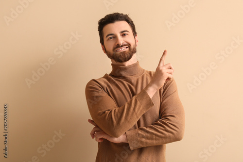 Young man pointing up on be...