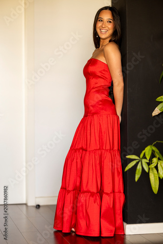 Young woman in a red party dress smiling