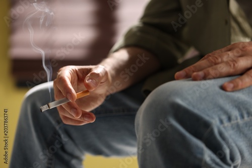 Tableau sur toile Man smoking cigarette at home, closeup. Bad habit