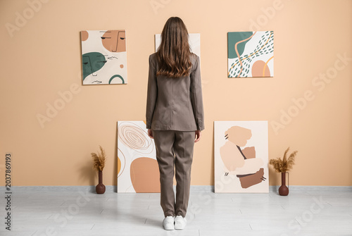 Young woman near paintings ...