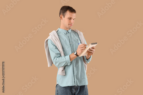 Young businessman writing i...