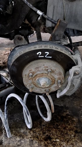 Camera tilts down to reveal a rusty car brake assembly