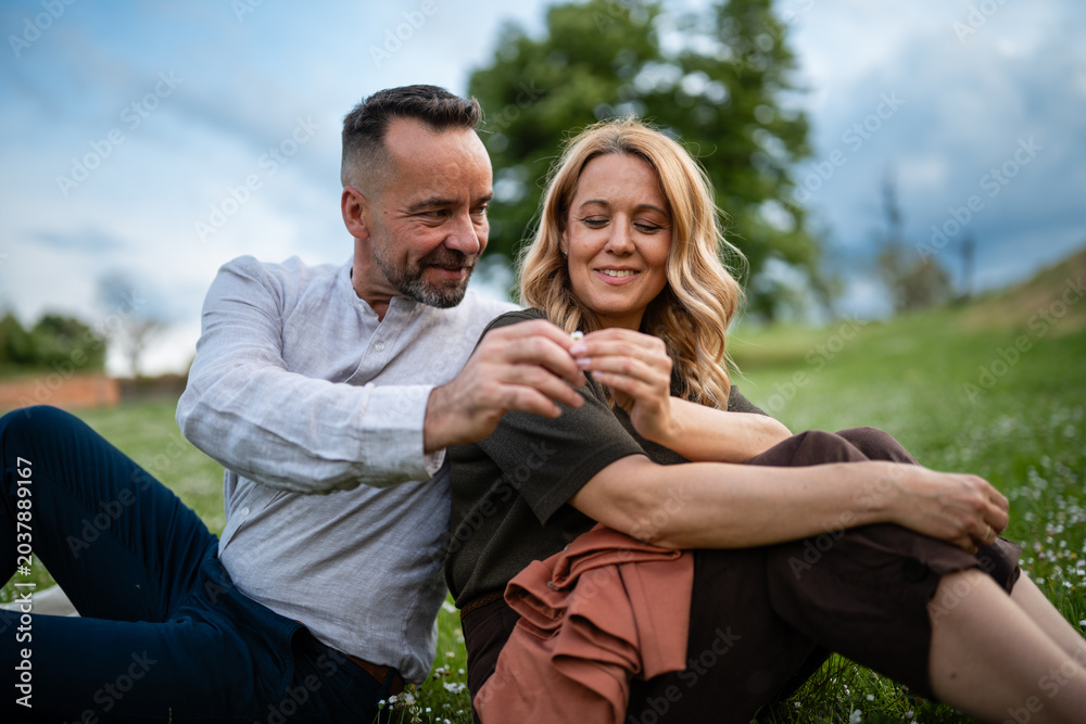 Fototapeta premium Happy couple relaxing on grass in nature