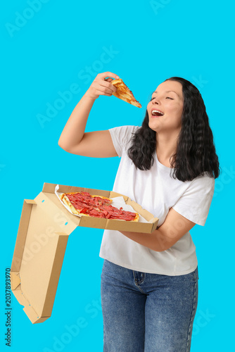 Young woman eating tasty pi...