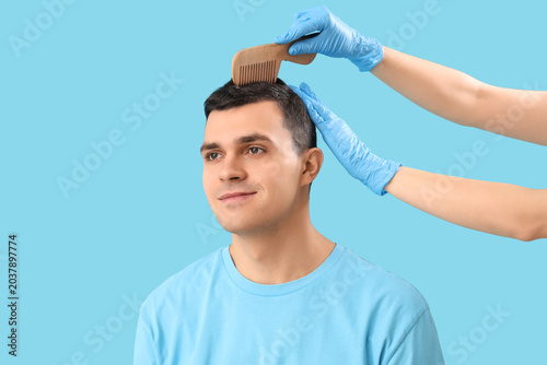 Doctor combing young man's ...