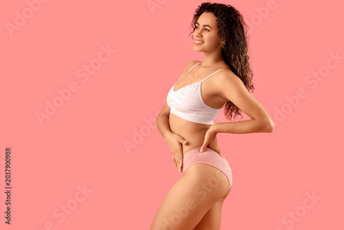 Foto Young African-American woman in menstrual panties on pink background