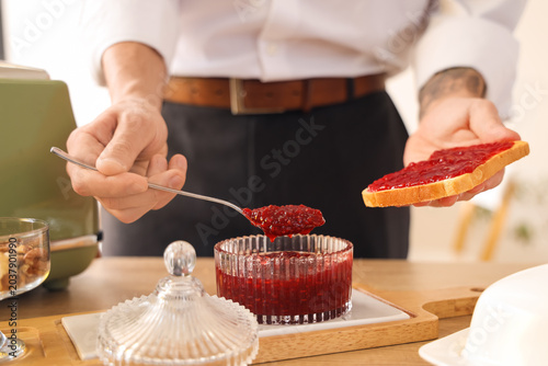 Young man making sweet jam ...