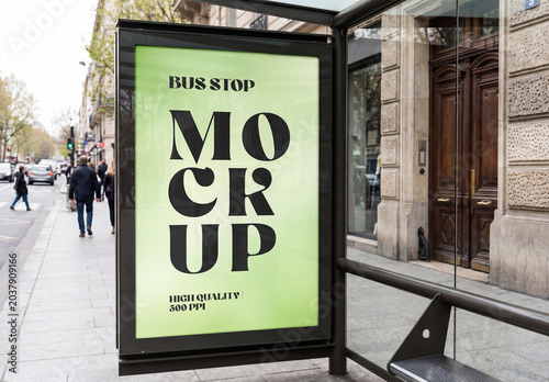 Vertical bus stop billboard mockup on a city street sidewalk with pedestrians and classic architecture buildings background