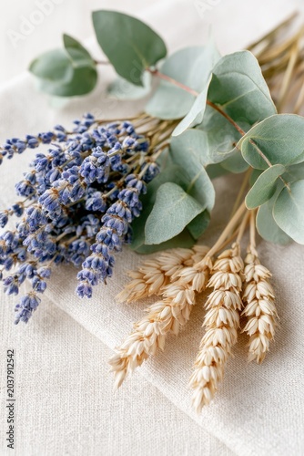 Dried lavender bouquets and eucalyptus branches arranged on a light fabric surface, showcasing natural textures and colors in a decorative composition
