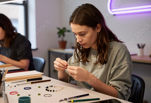 Young Woman Making Handmade Jewelry with Recycled Materials