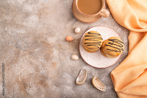 Caramel Cream Cakes on brown concrete, cup of coffee, top view, flat lay, copy space
