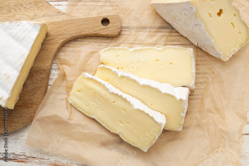 Schilderij op canvas Slices of delicious brie cheese on color wooden table, flat lay