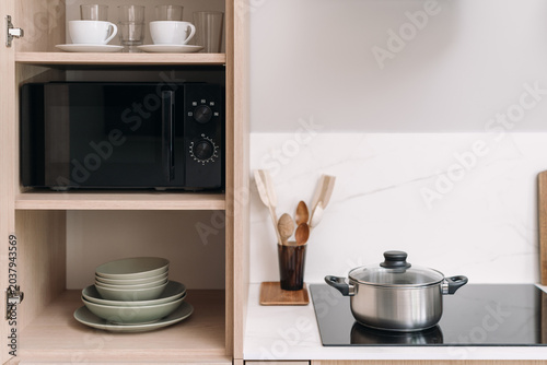 Tableau sur toile Modern kitchen interior with built-in microwave and minimalist cooktop