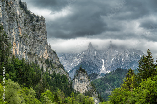 Dramatic Alpine Mountains with Storm Clouds and Forest