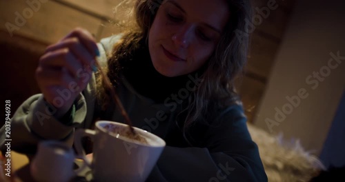 Young Woman Enjoys Hot Chocolate in Cozy Winter Cafe Ambiance