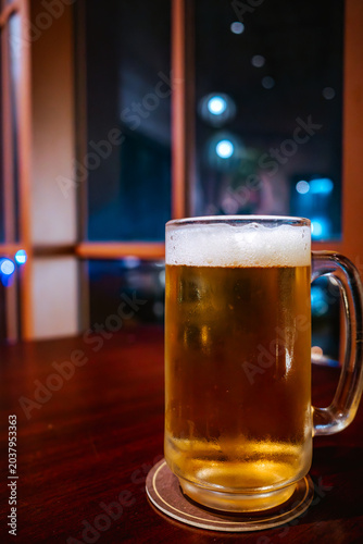 Fotografi Close up shot of a cold mug of draft beer with bubbles on a wooden table for bar menu