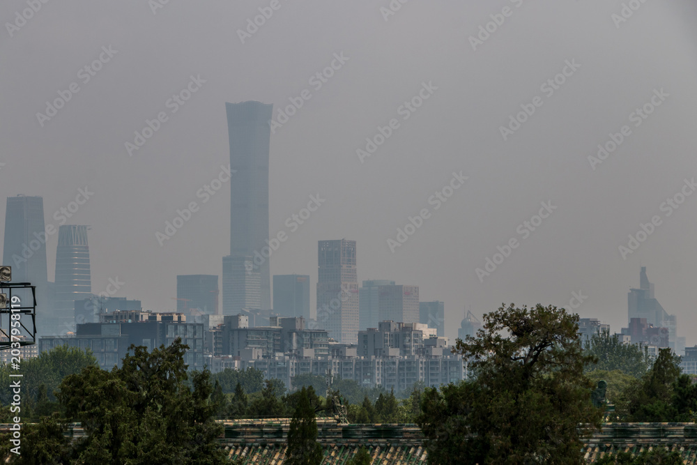 Fototapeta premium Skyscrapers and buildings shrouded in smog. Heavy air pollution in Beijing - China. Beijing Dontown (CBD) and China Zun