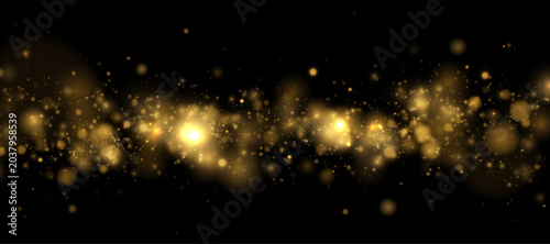 Fotografie Golden spark particles scatter in air forming soft luminous trails