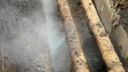 Workers performing emergency maintenance and accident elimination on damaged underground heating pipes