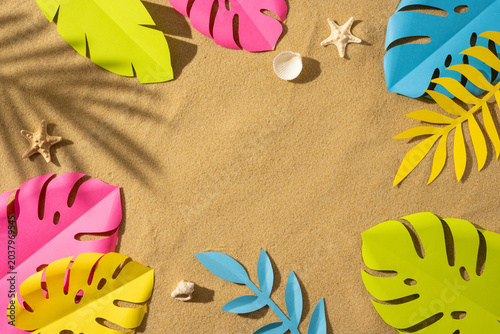 Foto Summer beach scene with colorful paper tropical leaves, shell and starfish on sa