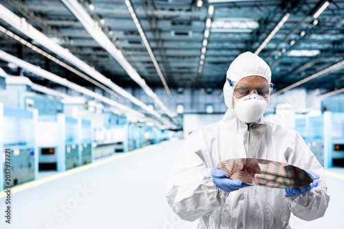 Schilderij op canvas Analyzing processed silicon wafer, cleanroom and man in automated fabrication plant, Examining microelectronics for defects, semiconductor substrates and specialist doing quality control