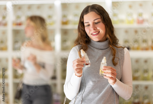 Fotografie Girl sniffs fragrance of perfume, choose scent spray with pleasant smell