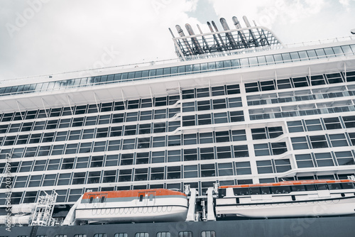 Foto Low angle view of a large white cruise liner with rows of cabin windows, orange