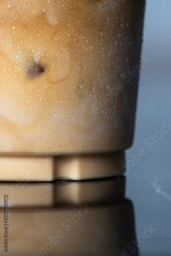close-up iced coffee plastic cup covered in cold water droplets and condensation.
