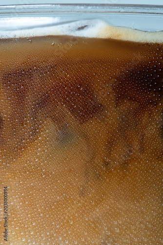 close-up iced coffee plastic cup covered in cold water droplets and condensation.