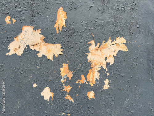 Surface transformation revealing aged layers beneath a weathered charcoal facade