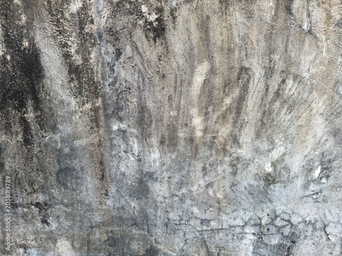 Weathered cement facade displaying a rich tapestry of grayscale tones and raw rustic details