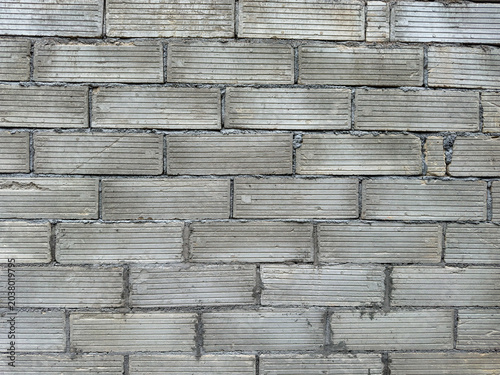 Weathered utilitarian grey blockwork showcasing intricate linear patterns on a durable structural