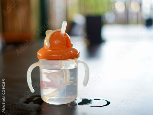 Baby care essentials, a water bottle on a wooden table with soft natural lighting and blurred background
