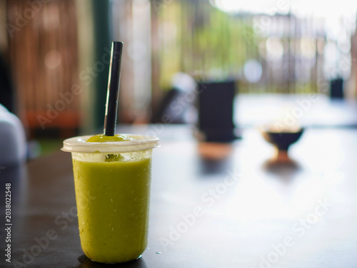 фотографія Fresh mango juice and avocado juice in plastic cups with straws, captured in a c