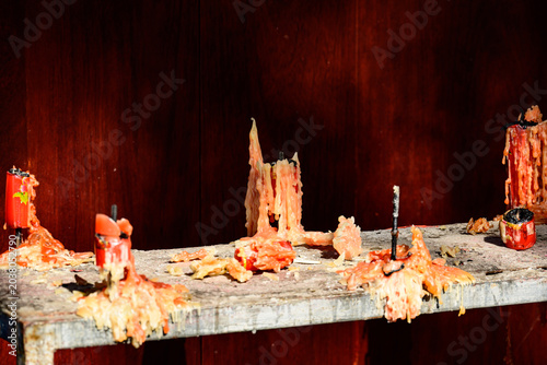 Φωτογραφία Candle wax drips and pools on an old altar, showing traces of devotional offerings against a dark wooden background