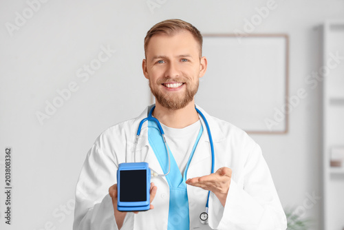 Male doctor with payment terminal in clinic