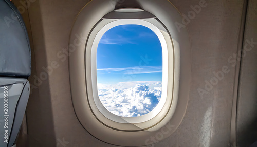View from airplane window showing clouds and blue sky, travel and journey concept