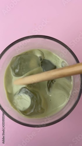 Iced Matcha Latte with Ice Cubes on Pink Background