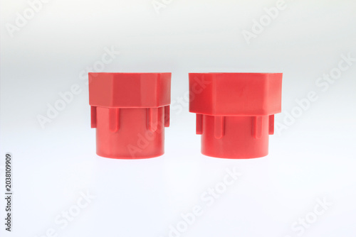 Photos wo red plastic fittings stand side by side hexagonal socket adapters for multifunction basin wrench isolated on white background