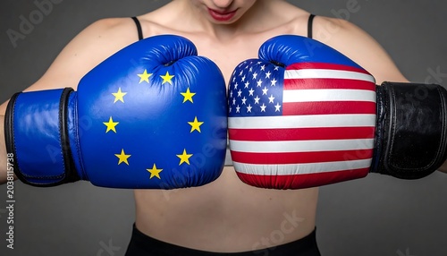 Close-up of a person with bare chest, wearing boxing gloves adorned with the EU flag and the US flag, fists clasped