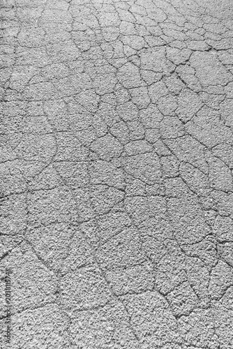 Photo of a cracked asphalt surface. Cracks on a concrete road.