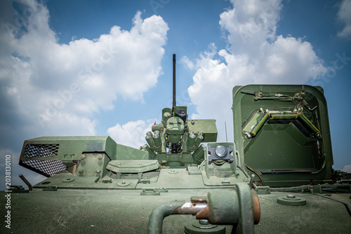 Fotografie Low angle view of a modern military remote weapon station (RWS) equipped with a heavy machine gun, optical sensors, and smoke grenade launchers under a blue sky