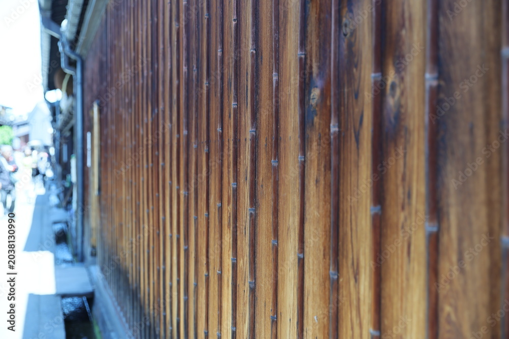 Obraz premium A traditional Japanese wooden wall features vertical bamboo strips.