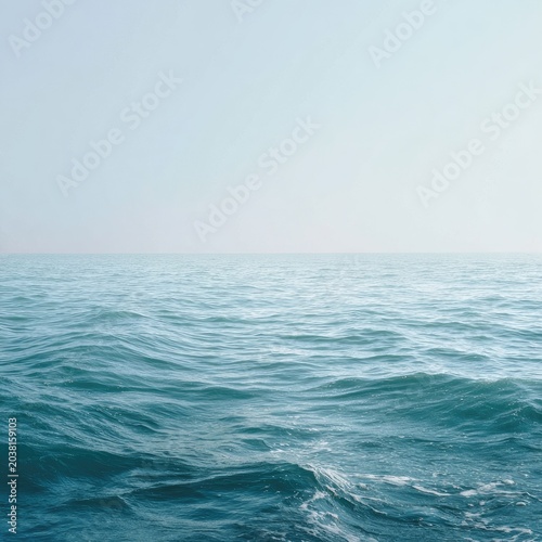 Turquoise ocean with soft waves under a pale sky