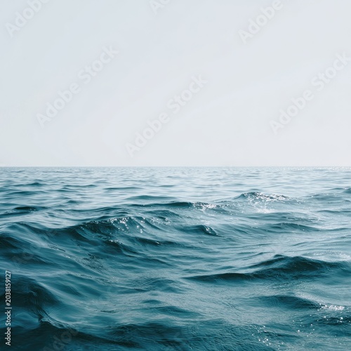 Calm ocean surface under a hazy, cloudless sky