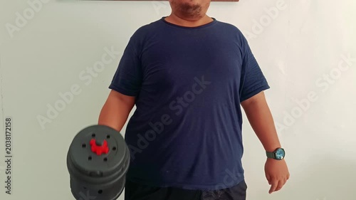 Overweight Man Performing Hammer Curl Dumbbell Exercise at Home
