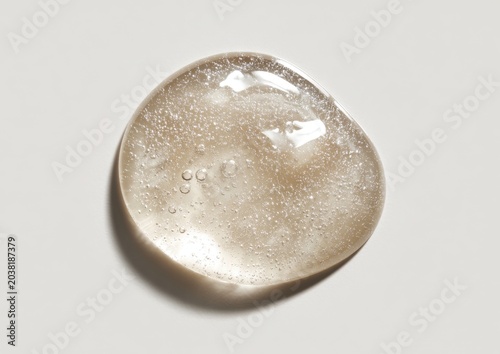Single round globule of clear gel with fine glitter specks background transparent cosmetic hydration moisture reflective fluidity abstract material substance