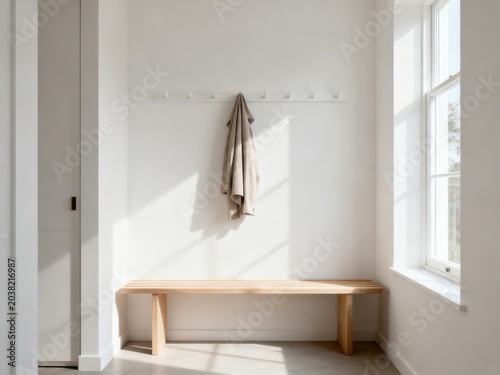 Minimalist scandinavian entryway with a wooden bench and coat hanging on a wall hook